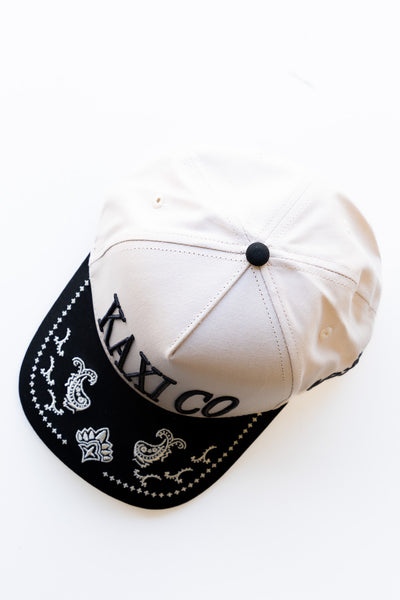 White cap with black brim and embroidered text on a white background