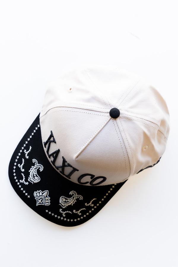 White cap with black brim and embroidered text on a white background