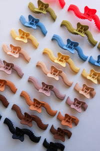 Colorful hair clips arranged in a grid on a white background