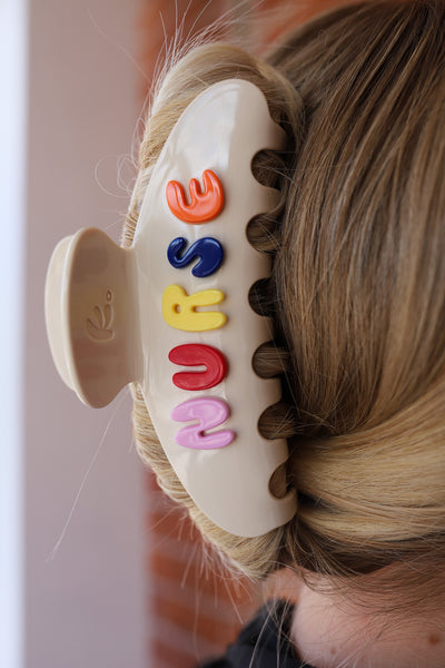 Colorful hair clip with letters spelling 'NURSE' on a blurred background