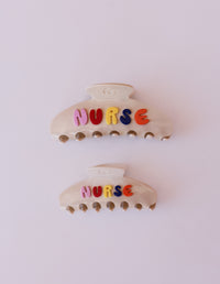 Two hair clips with 'NURSE' letters on a white background