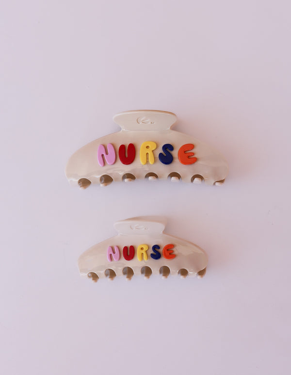 Two hair clips with 'NURSE' letters on a white background