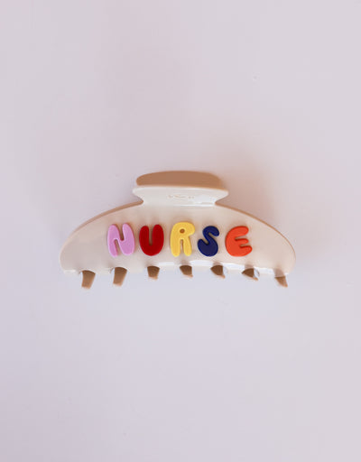 Hair clip with colorful letters spelling 'NURSE' on a white background
