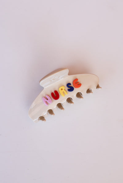 cream claw clip with 'NURSE' letters on a light background