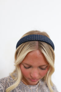 Woman wearing a denim headband with gold studs on a white background