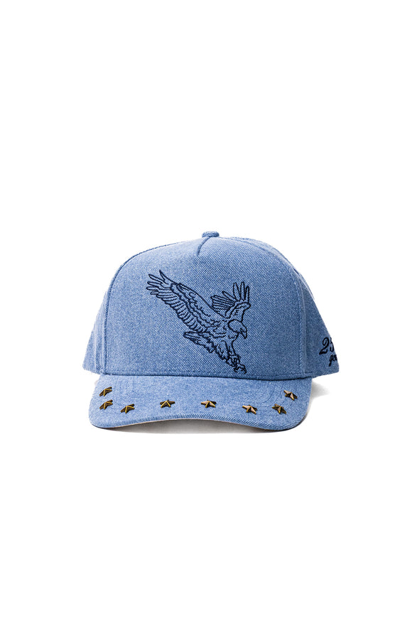 denim blue trucker hat with an eagle embroidered on the front, and studs on the brim 