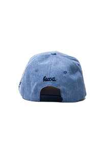Blue denim cap with "kaxi" logo on a white background