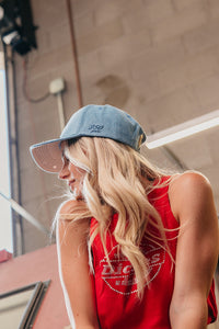 woman wearing a denim blue trucker hat with "250 years" embroidered on the side
