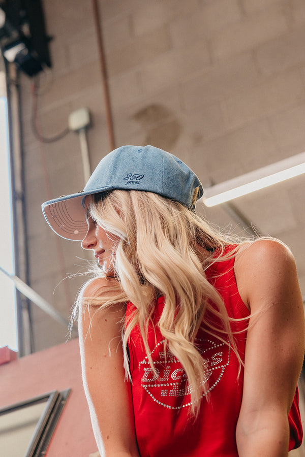 woman wearing a denim blue trucker hat with "250 years" embroidered on the side