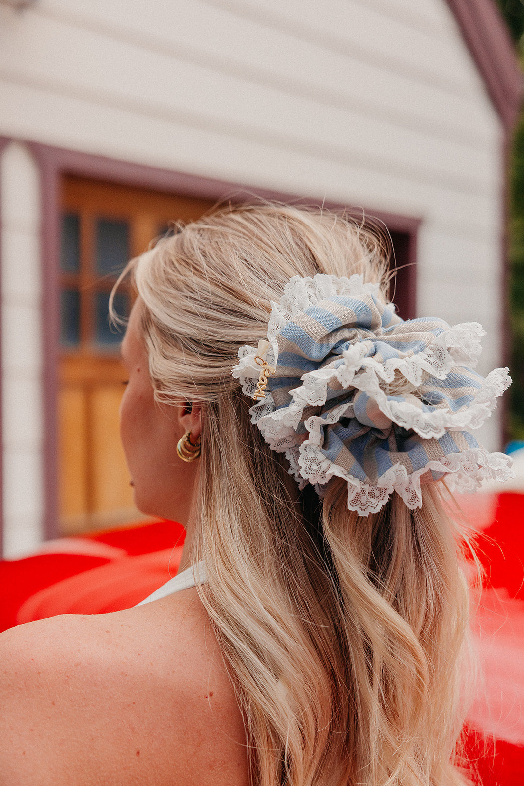 Girl with a blue and cream striped scrunchie with lace on the edges.