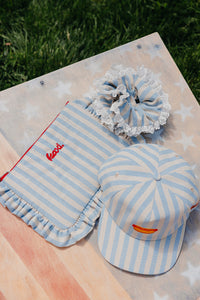 striped blue and white baseball cap with a hot dog embroidered on the front, a matching blue and white striped scrunchie, and matching blue and white striped cosmetic bag