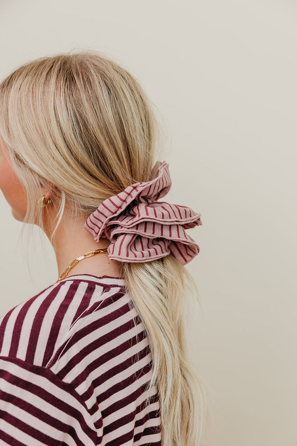 Girl wearing a striped scrunchie in her hair.