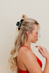 Woman with blonde hair wearing a black headband with 'Gym Girl' text against a plain background