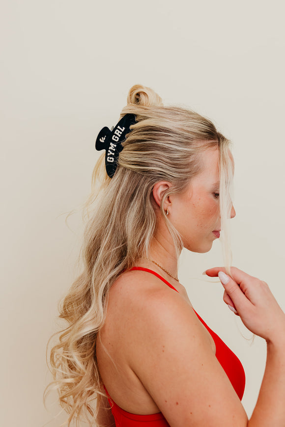 Woman with blonde hair wearing a black headband with 'Gym Girl' text against a plain background