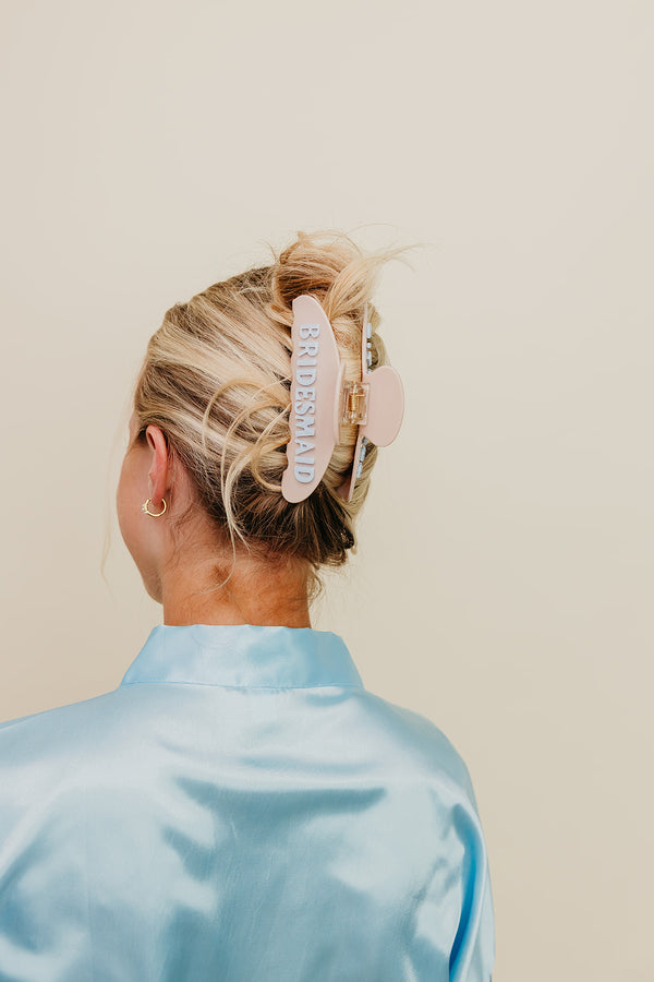 Person with a bridesmaid claw on a plain background